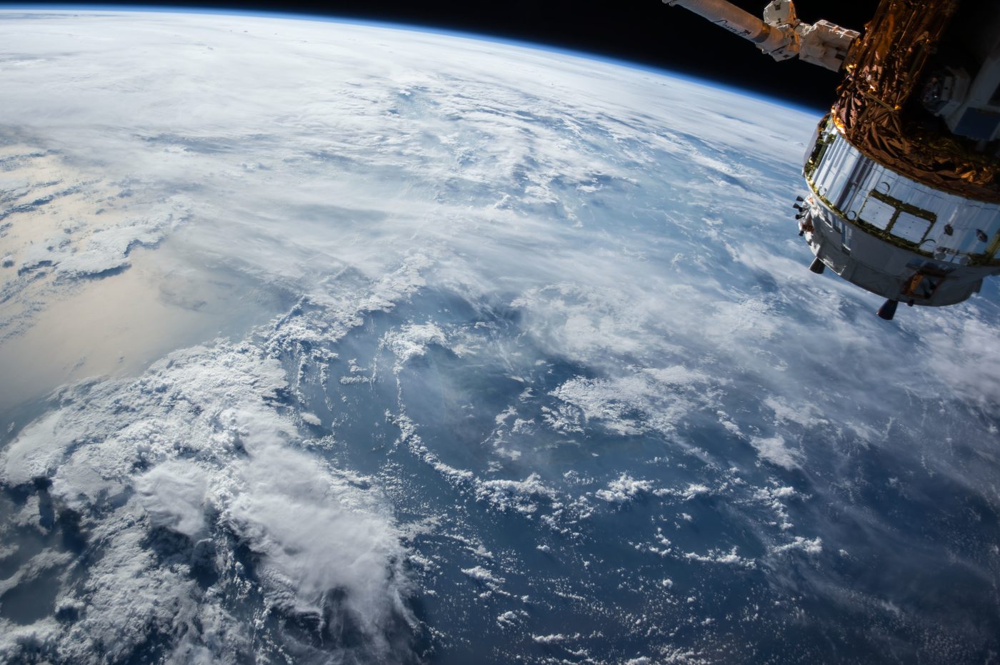 Earth seen from orbit with a spacecraft at the edge of frame