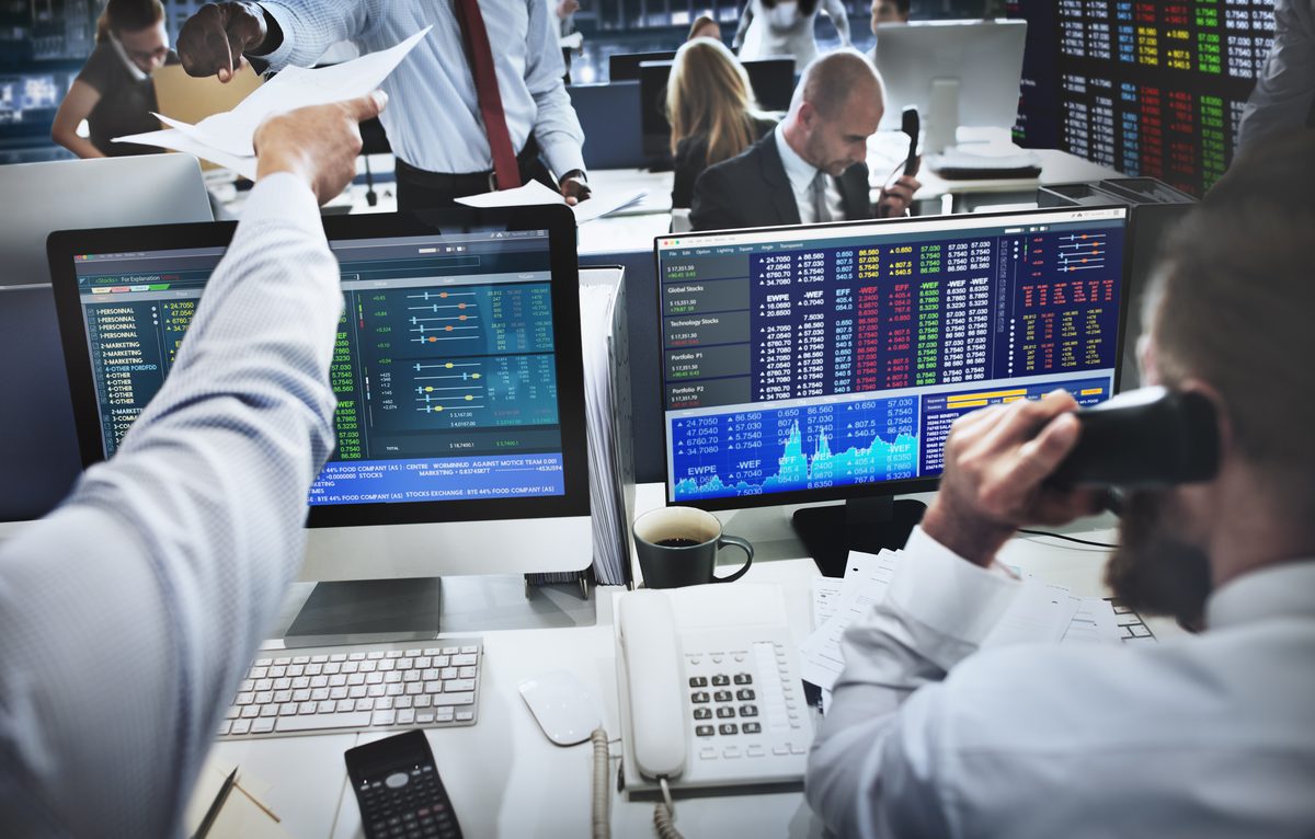 Analysts at a trading desk with market screens